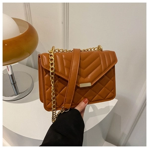 Top-down view of a brown quilted crossbody bag with gold chain and metal buckle