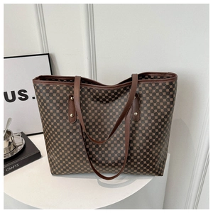 Detailed view of dark brown tote bag with geometric circular patterns and metal rivets