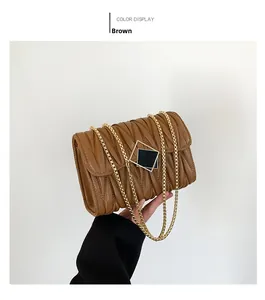 Vue détaillée du sac à main marron matelassé avec chaîne dorée et boucle carrée