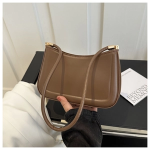 Detail view of smooth brown PU leather shoulder bag with polished gold hardware and strap