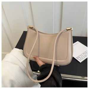 Detail of beige hobo bag with sleek leather texture and gold hardware accents