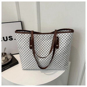 Close-up of geometric pattern on white tote bag with brown leather handle details