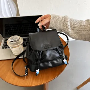 Detalle de mini mochila negra de cuero PU con grabado de moda y adornos de cuentas