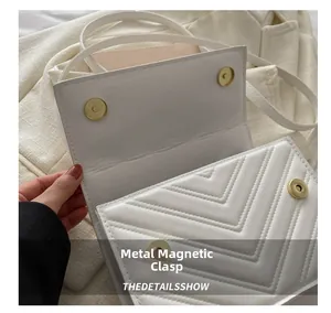 Détail du sac matelassé blanc montrant le fermoir magnétique doré et la texture du cuir