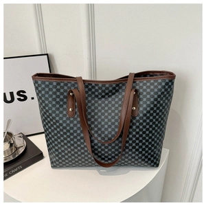 Close-up of geometric pattern tote bag with leather straps and gold rivets