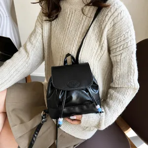 Detalle de la mini mochila de cuero sintético negro con cuentas azules y blancas