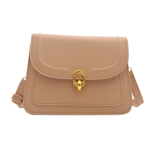 Minimalist beige crossbody flap bag with a golden oval buckle and adjustable strap