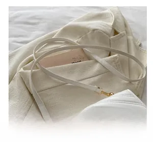 Détail du sac matelassé blanc avec boucle en métal doré et bandoulière confortable et chic