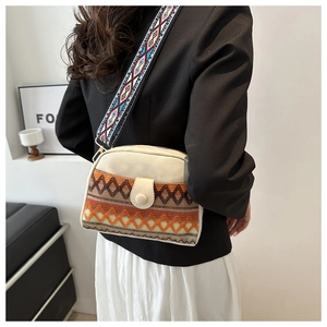 Détail du sac coquille ethnique avec broderie orange et large bandoulière tissée