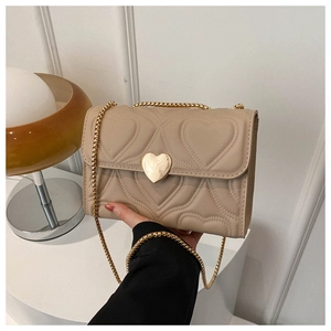 Détail du sac à bandoulière en cuir PU beige avec matelassage cœur et boucle cœur dorée