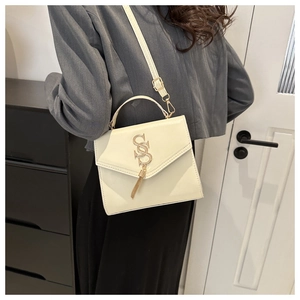 Detail of cream white leather shoulder bag with SSS metal logo and chain tassel