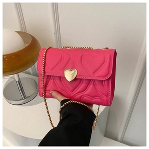 Détail du sac à bandoulière matelassé rose avec fermoir cœur doré et chaîne en métal
