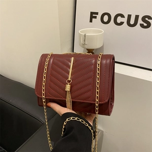 Minimalist burgundy quilted crossbody bag with gold chain strap and tassel detail