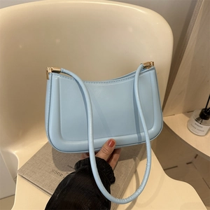 Minimalist light blue PU leather baguette bag with slender shoulder strap in home setting