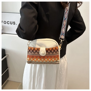 Close-up of ethnic crossbody bag with geometric tapestry pattern and jacquard strap