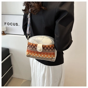 Close-up of bohemian canvas crossbody bag with orange geometric weaving and woven strap