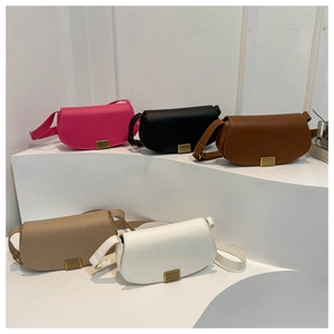 Minimalist solid color saddle crossbody bags in five colors on white display pedestals