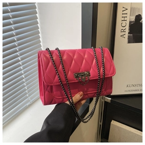 Detail of fuchsia quilted chain crossbody bag with gunmetal clasp and elegant stitching