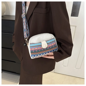 Détail du sac coquillage en toile avec motifs ethniques et bandoulière large