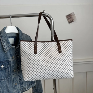 Retro patterned tote bag with brown leather straps and geometric black and white prints