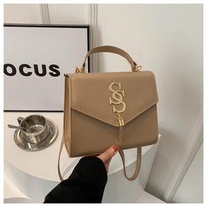Close-up of khaki leather handbag with gold SSS logo and elegant tassel detail