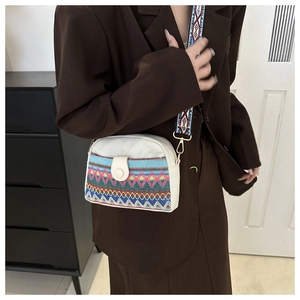 Close-up of ethnic woven canvas crossbody bag with colorful geometric strap