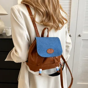 Detail eines Vintage-Patchwork-Rucksacks mit Denim-Klappe und Leder-Mode-Logo