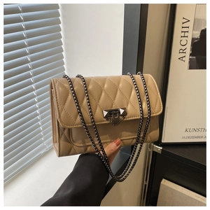 Close-up of khaki quilted crossbody bag with diamond stitching and metal chain strap