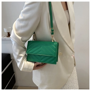 Détail du sac bandoulière vert matelassé en V avec des boucles en métal doré chic