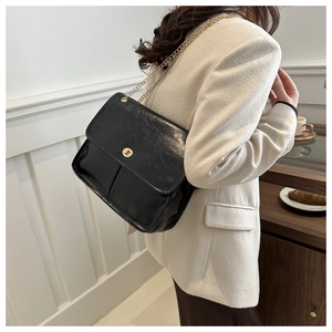 Chic black vintage shoulder bag with gold chain strap and textured leather finish