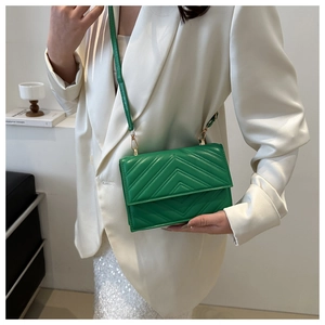Détail du sac à rabat vert en cuir PU surpiqué avec des finitions dorées chic