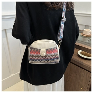 Close-up of ethnic style crossbody bag with geometric pattern and colorful wide strap