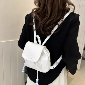 Detalle de mini mochila de cuero PU blanco con solapa y cordón con cuentas blancas