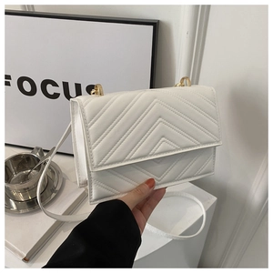 Vue détaillée du sac bandoulière blanc matelassé avec garnitures dorées et motif en V