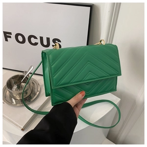 Détail d'un sac bandoulière en cuir PU vert avec surpiqûres en V et garniture dorée