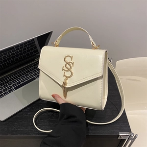 Cream-colored minimalist crossbody bag with gold S-buckle and tassel for women