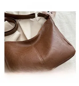 Dettaglio della trama in pelle PU retrò e cuciture fini sulla borsa tote marrone scuro