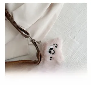 Dettaglio del ciondolo a forma di animale in peluche sulla tracolla della borsa hobo