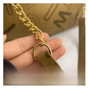 Detail of lychee textured leather tote with golden D-ring and chain shoulder strap