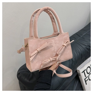 Détail du sac à main rose à nœuds avec finition mate et structure rectangulaire chic