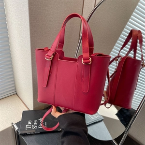 Fashionable red matte leather bucket bag with gold hardware and versatile crossbody strap