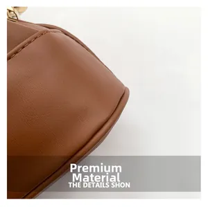 Makroaufnahme einer braunen Leder-Beuteltasche mit feiner Textur und goldenen Metallschnallen