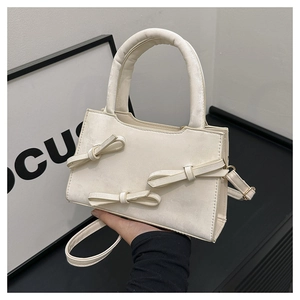 Détail du mini sac à main crème avec trois nœuds 3D élégants et une poignée robuste