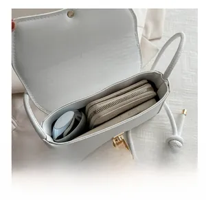 Internal view of a white leather crossbody bag showing its storage capacity and pockets