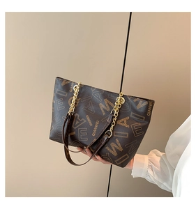 Close-up of brown tote bag with leather chain strap and elegant letter print design