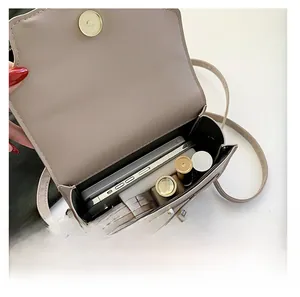Internal view showing storage space for smartphone and makeup in beige saddle bag
