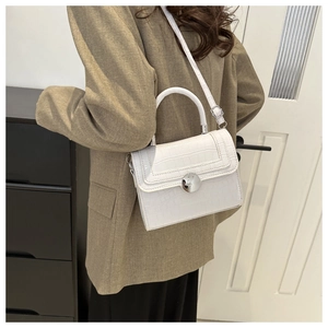 Detailed view of white crocodile pattern crossbody bag with silver round buckle