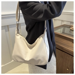 Dettaglio della borsa hobo bianco sporco con tracolla regolabile indossata dalla modella