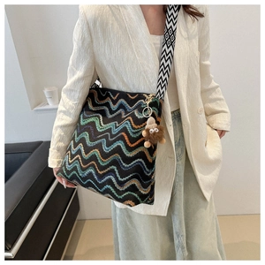 Detail of bohemian knit tote bag with colorful wave patterns and geometric wide strap