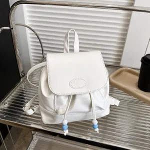 Detalle de mini mochila blanca en cuero PU con cordón y solapa grabada Fashion